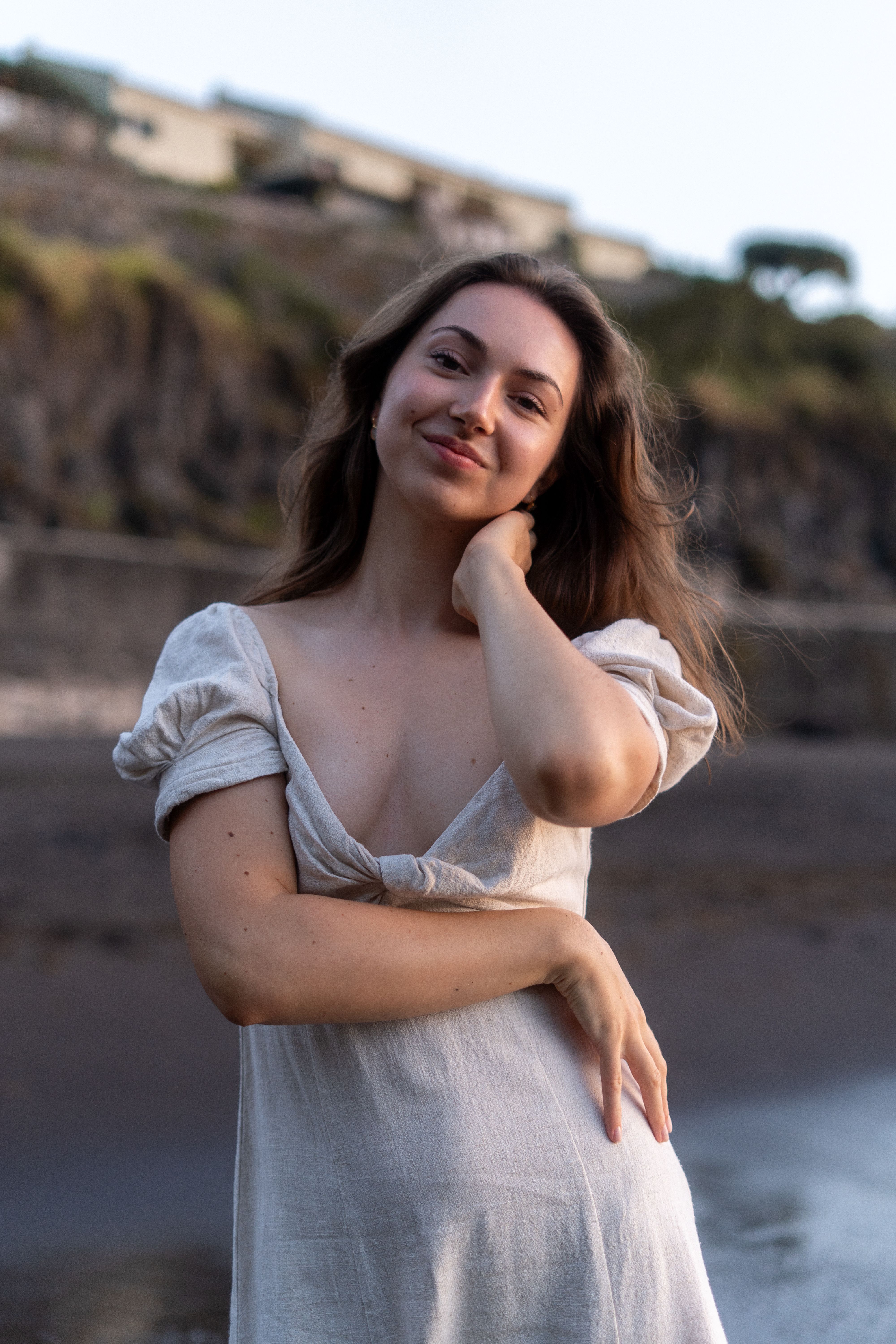 Frau im weißen Kleid steht am Strand